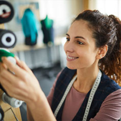 woman pulling yarn from a spindle
