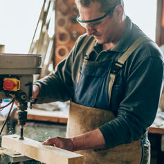 man drilling into a piece of wood